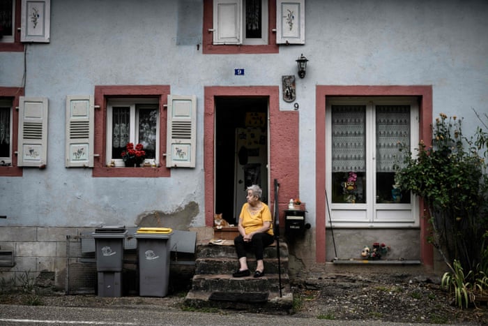Tour de France Women: Van Vleuten aims for glory in the last stage – live! | Tour de France Women 1 An elderly woman waits for cyclists with her cat at her doorstep.