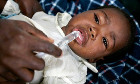 A nurse giving sugar solution to a child suffering from cholera in Zimbabwe in 2009.