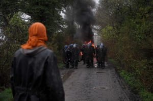 A protester looks at riot police during the eviction of environmental activists from the site of a proposed new airport.