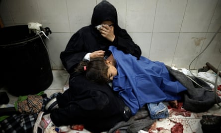 A Palestinian woman cries as she sits next to her daughter, wounded in an Israeli attack at Nasser hospital in Khan Younis on Monday.