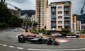 Lewis Hamilton takes a hairpin on the circuit in Monaco with tall buildings in the background during practice