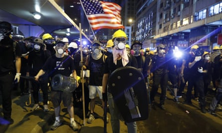 Protesters prepare to confront riot police while waving a US flag