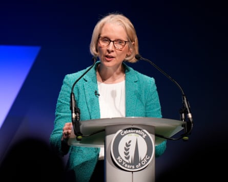 Emma Reynolds stands at a podium, delivering her speech to the conference