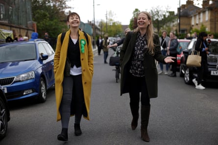 Lucas and Sian Berry walk together down the middle of a London street.