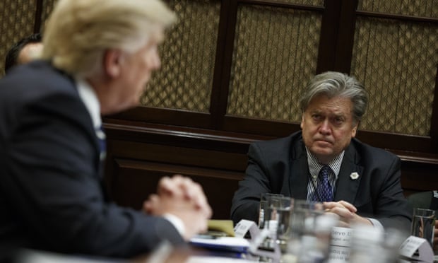 Steve Bannon listens at right as President Donald Trump speaks during a meeting in the Roosevelt Room of the White House.