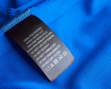 Black laundry care washing instructions clothes label on blue jersey polyester sport shirt