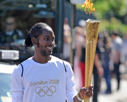 Jason Arday carries the Olympic Flame on the Torch Relay leg between Sutton (London Borough) and Merton (London Borough).