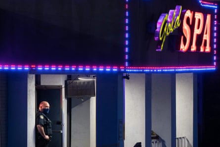 A police officer stands outside a massage parlor where three people were shot and killed on 16 March 2021, in Atlanta, Georgia.