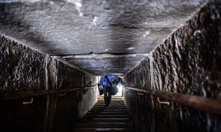 a man walks through the narrow passageway in the bent pyramid in Dahshur , Egypt
