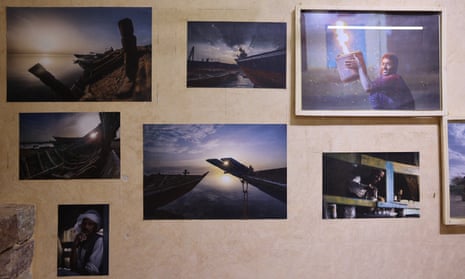 A mixture of framed and unframed photographs by Mohammed Altaj hang on the wall