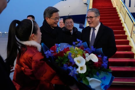 Keir Starmer receiving a bouquet of flowers upon his arrival.