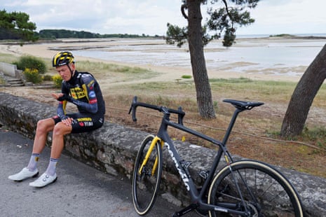Robert Gesink rests on a wall after crashing out.