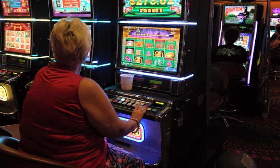 A woman plays a poker machine