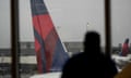 A Delta airplane waits at an airport gate.