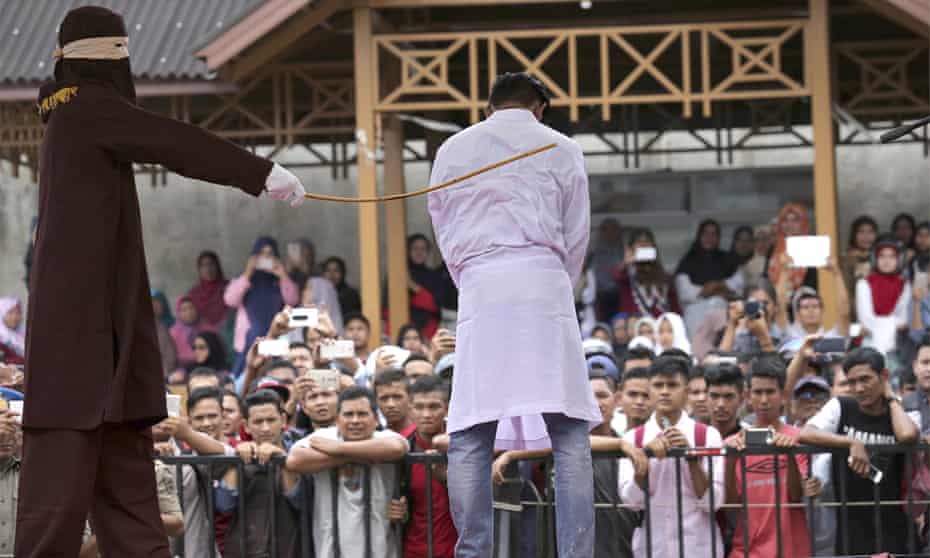 A Sharia law official whips a man convicted of adultery with a rattan cane in Banda Aceh.