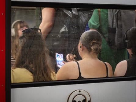 People sitting inside a carriage, seen through a window.