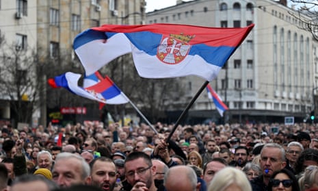 Protesters wave Serbian flags at a pro-democracy rally in Belgrade