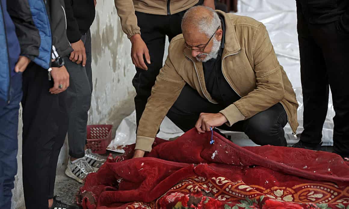 A man mourns the body of his loved one killed during an Israeli strike in Gaza City on 13 January.