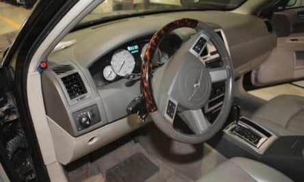 The interior of a left hand drive car, modified with a red button near the driver’s door, according to prosecutors