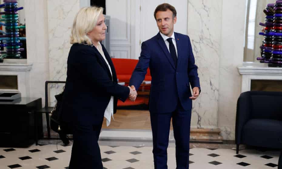 Marine Le Pen shakes hands with President Emmanuel Macron after talks at the presidential Elysee Palace.