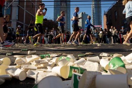 Runners get drinks at a hydration station as they compete in last year’s New York City Marathon.