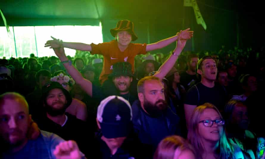 Ett Liverpool-fan ser Jamie Webster uppträda på den vänstra scenen under Glastonbury-festivalen på Worthy Farm i Somerset.