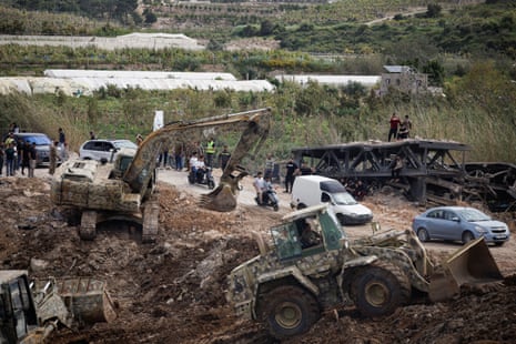 Heavy machinery on a bridge as some cars are able to get past.