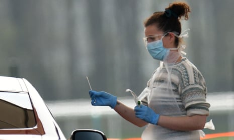 A health worker tests an NHS employee at a drive-in testing station in Merseyside.