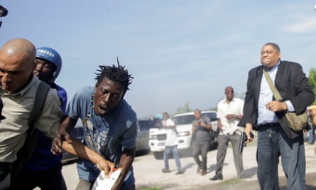 People run as Haiti’s Senator Jean Marie Ralph Féthière holds a gun in Port-au-Prince, Haiti.