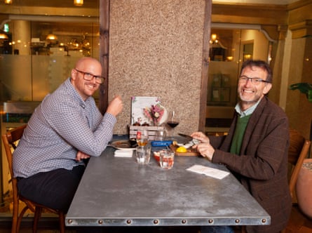 Dua pria berhadapan di meja restoran