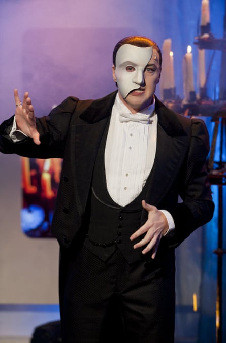 A man in evening dress with a white mask over his face