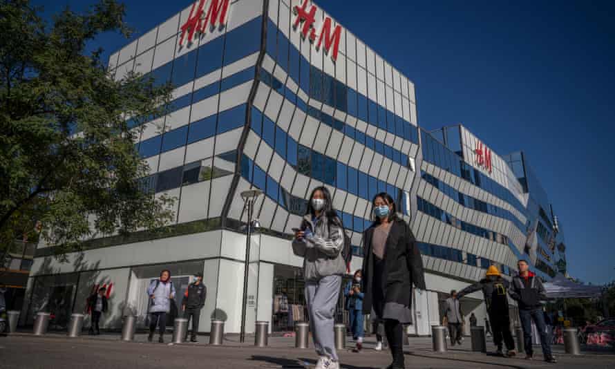 Shoppers pass an H&M store