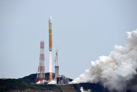An H3 rocket carrying six small satelliteslifts off with flames soaring from its base and a huge trail of white smoke.