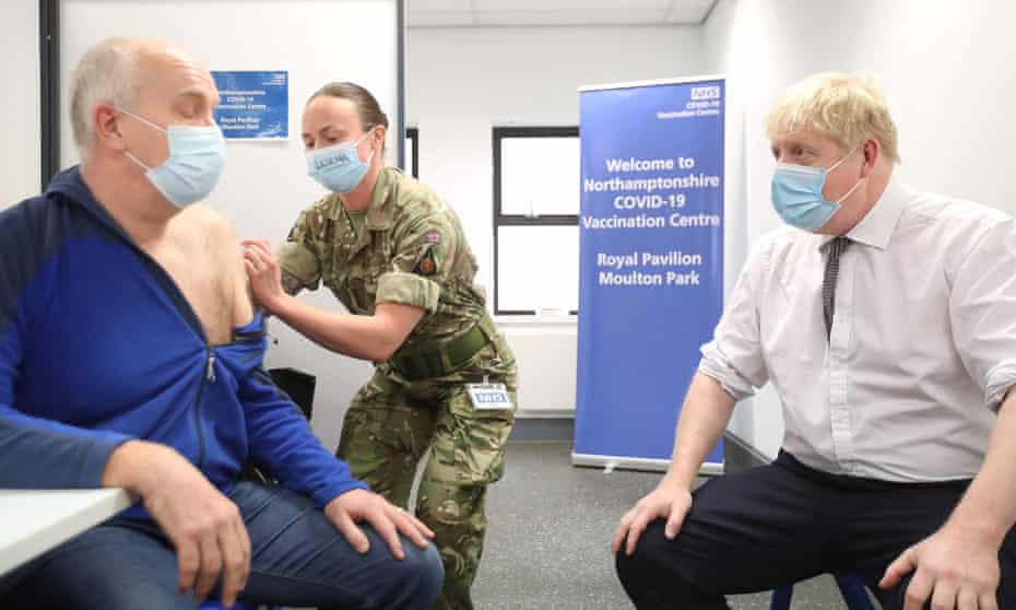 Boris Johnson watches as a coronavirus vaccination is administered at a centre in Northampton.