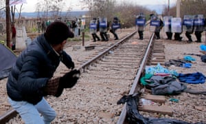 Migrants hurl stones at Macedonian policemen during clashes as the migrants protest against the building of a metal fence at the Greek-Macedonian border.