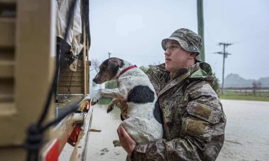 A member of the New Zealand Defense Force rescues a dog from floods as they assist a family with their evacuation near Ashburton in New Zealand’s South Island, Sunday May 30, 2021. Several hundred people in New Zealand were evacuated from their homes Monday, May 31, 2021 as heavy rainfall caused flooding in the Canterbury region. (Corp. Sean Spivey/NZDF via AP)