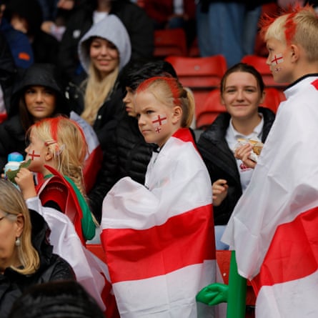 Young England fans draped in St George’s flags take their seats during the Women’s Rugby World Cup 2025 semi-final match between England and France.
