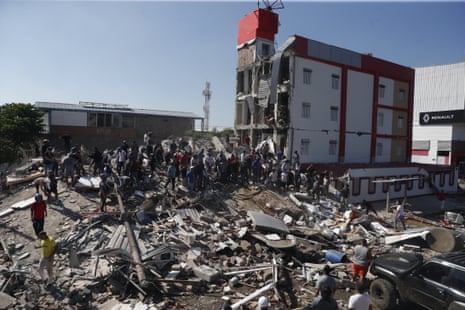 People walk through the rubble of a collapsed building after an earthquake in Cali, Colombia, 10 August 2026.