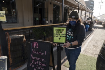 Blanca Quintero, a restaurant worker, sets up a sign asking customers to show proof of Covid-19 vaccination at Highland Park Brewery in Los Angeles.