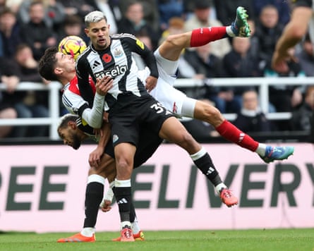 The Newcastle midfielder Bruno Guimarães battles for a loose ball with the Arsenal forward Kai Havertz.