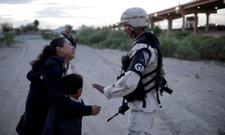 Guatemalan migrant Ledy Pérez embraces her son while facing Mexico’s National Guard. A third of the militarized police force have been deployed to the border