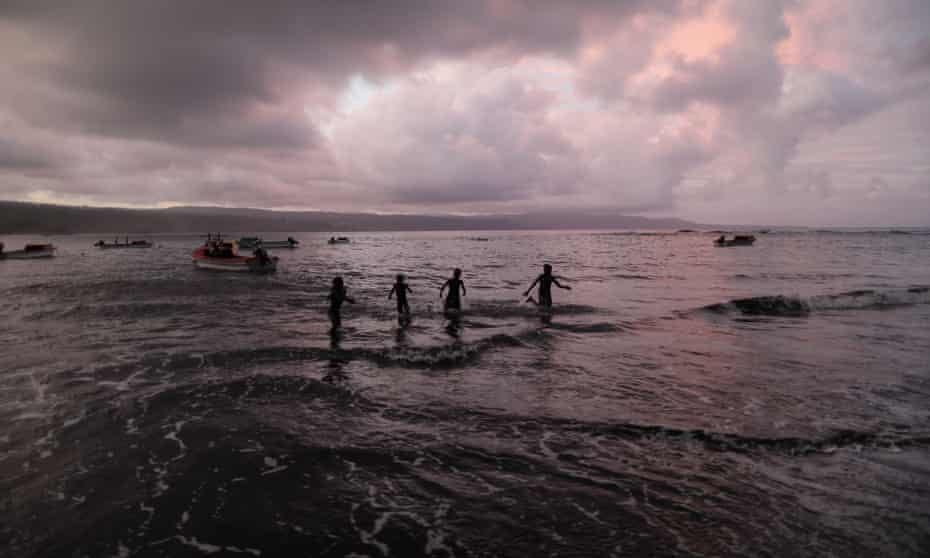 Silhouettes of people in the sea