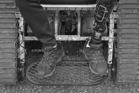 A person with a mechanized leg wears hiking shoes and sits on a Trackchair