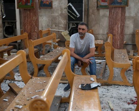a man sitting in a bomb-damaged church