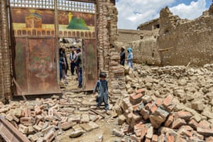 Bernal, Afghanistan. A child walks past the gate of a house damaged by the earthquake in Paktika province