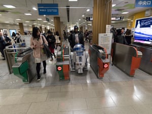 Richard and R2-J1 leave a suburban train station