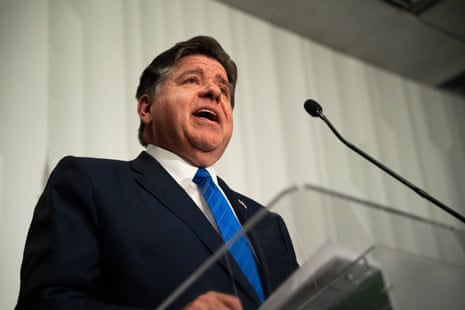 JB Pritzker standing in front of a microphone.