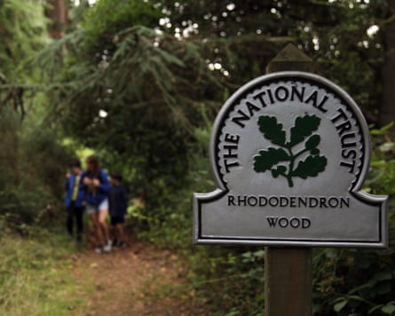 A family explore walking in the woods at The Rhododendron Wood, Leith Hill, Surrey, UK,