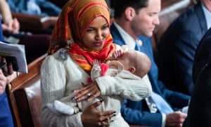 Ilhan Omar holds the child of the Democratic representative Eric Swalwell during Thursdayâs ceremonies.