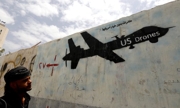 A Yemeni man looks at graffiti showing a US drone